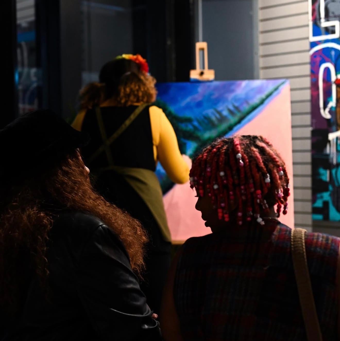 Guests watching Reinilda paint live at an evening event