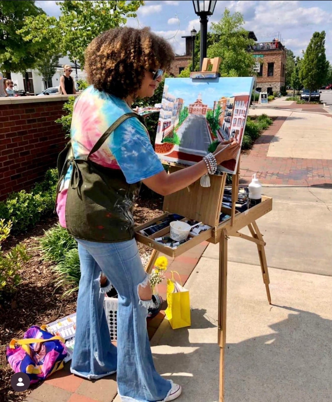 Reinilda painting a cityscape live at a street festival